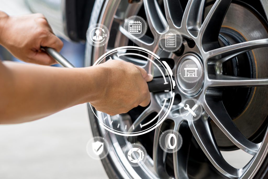 Zertifizierte Ford-Techniker führen einen Transit-Service-Check durch: Radmuttern lösen für Bremseninspektion, während die Mobilitätsgarantie per Tablet-Checkliste digital bestätigt wird – professionelle Fahrzeugdiagnose mit Zukunftstechnologie.